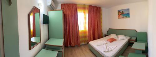 a small room with a bed and a mirror at Vila Pajura in Costinesti
