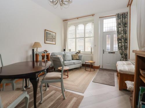 a living room with a table and a couch at Baht'at Cottage in Ilkley