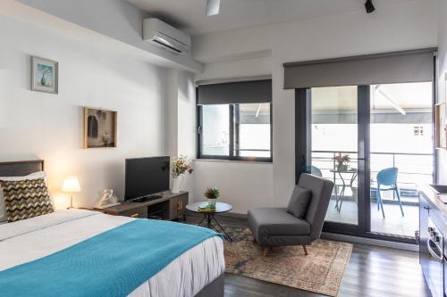 una camera con letto, sedia e televisore di Stay Kula Aparthotel city center ad Atene