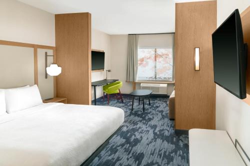 a hotel room with a bed and a desk at Fairfield by Marriott Inn & Suites Detroit Taylor in Taylor