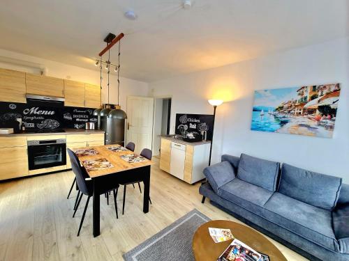 a living room with a table and a blue couch at Kappler Nest in Kappelrodeck