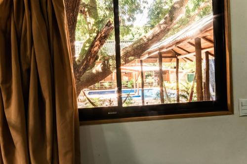 a window in a room with a tree at Rusteak Living Retreat in natural and peaceful setting in Canafistula in Cañafístula