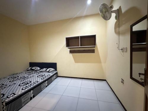 a small bedroom with a bed and a window at risky syariah in Kepanjen