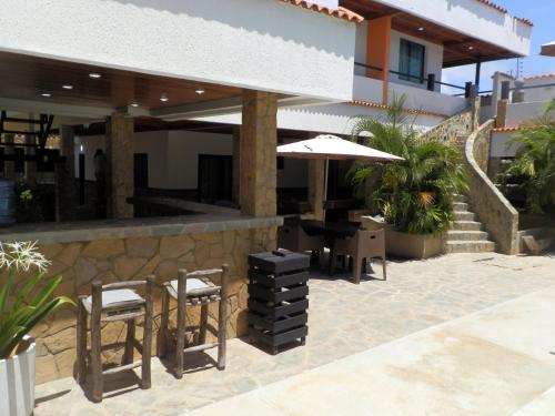 a patio with a table and chairs and an umbrella at Tu escapada en Chichiriviche Venezuela in Chichiriviche