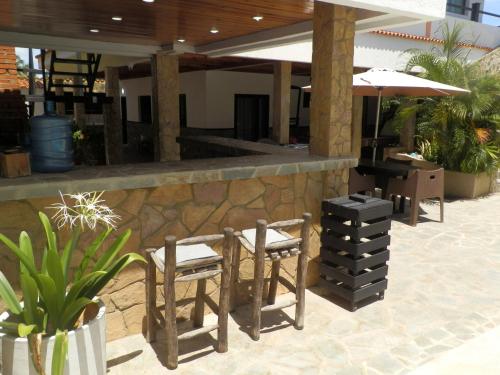 a patio with two chairs and a table and an umbrella at Tu escapada en Chichiriviche Venezuela in Chichiriviche