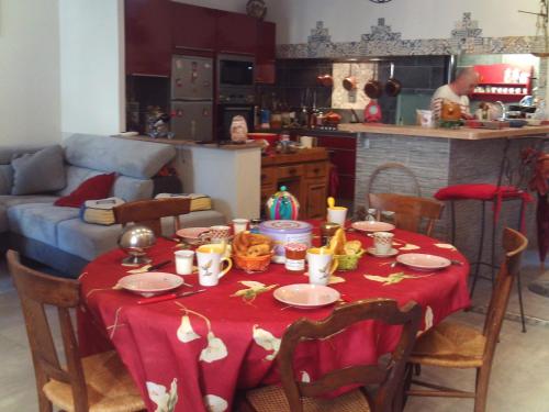 a table with a red table cloth on it in a kitchen at Chambre d hôtes Cap instant in Capestang