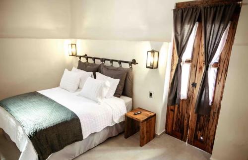 a bedroom with a white bed and a wooden door at Casa Romina in Guanajuato
