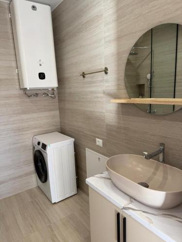 a bathroom with a washing machine and a sink at Everbright Seaside Serenity in Himare