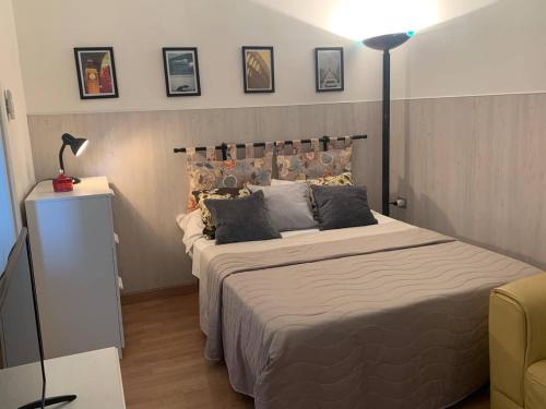 a bedroom with a large bed and a lamp at Appartamento Aurora Pro in Altamura