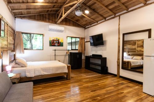 a bedroom with a bed and a tv and a couch at Rusteak Living Retreat in natural and peaceful setting in Canafistula in Cañafístula
