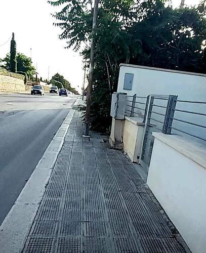 a sidewalk next to a road with a fence at Appartamento Aurora Pro in Altamura