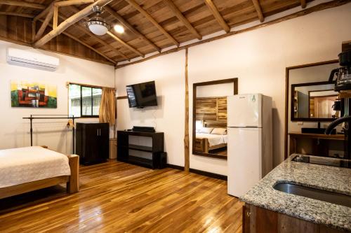 a kitchen with a refrigerator and a bed in a room at Rusteak Living Retreat in natural and peaceful setting in Canafistula in Cañafístula