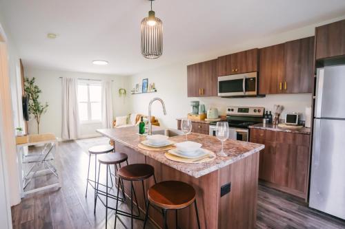 a kitchen with a large island with bar stools at Cozy & Stylish Laneway suite in Regina