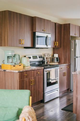 a kitchen with stainless steel appliances and wooden cabinets at Cozy & Stylish Laneway suite in Regina