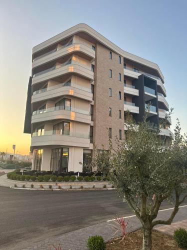 a tall building with a tree in front of it at Hotel Adler in Ulcinj