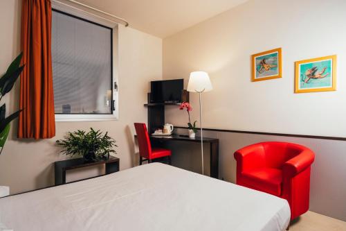 a hotel room with a bed and two red chairs at Euro Hotel in Imola