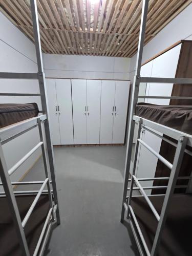 a room with two bunk beds and white cabinets at Kushtar in Bishkek