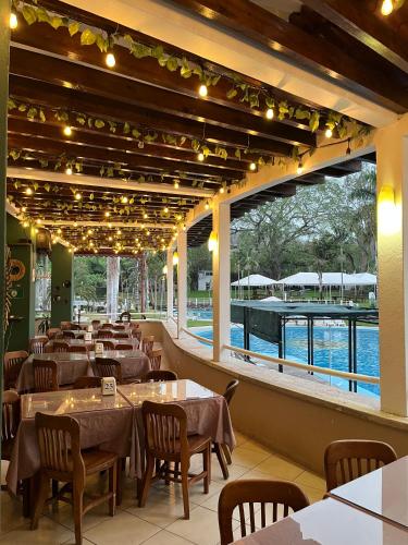 a restaurant with tables and chairs and a view of the water at Hotel Puente Nacional & Spa in Puente Nacional
