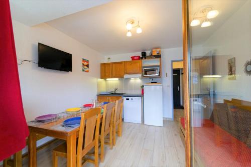 une cuisine et une salle à manger avec une table et des chaises dans l'établissement Au bon endroit N3 - Appartement 2 pièces 5/7 personnes - proche pistes - Belle vue montagne, à Orcières