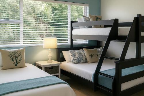 a bedroom with two bunk beds and a window at Hello Holiday at 4 Boboyi Mangrove Beach Estate in Port Shepstone