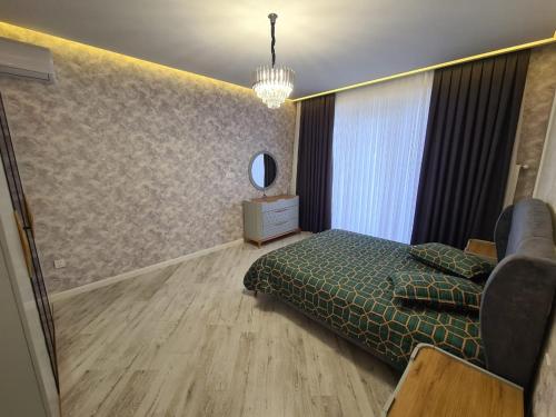 a bedroom with a bed and a couch and a mirror at Luxury villa Gabala ELM in Gabala