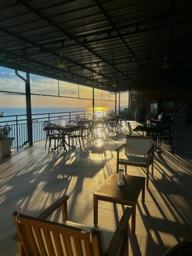 a patio with tables and chairs and the ocean at Belvedere in Pisciotta