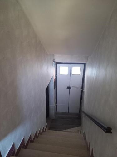 a stairway with a white door and stairs at A casa di Marti in Capodimonte