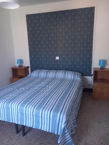 a bedroom with a bed with a blue and white comforter at A casa di Marti in Capodimonte