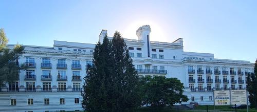 a white building with a tree in front of it at Vacation by the sea in Lapmežciems