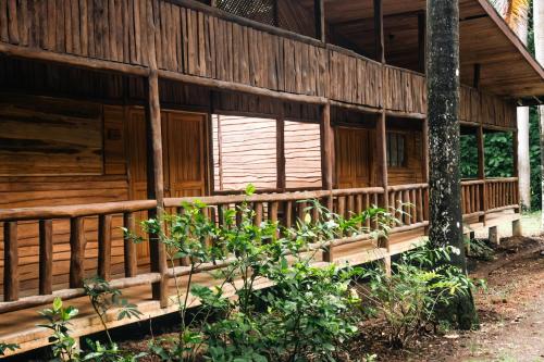 a wooden house with a porch and a window at Rusteak Living Retreat in natural and peaceful setting in Canafistula in Cañafístula