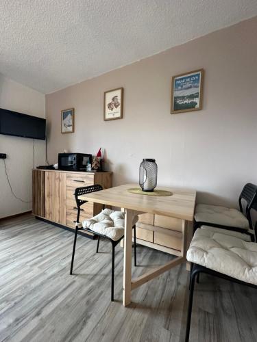 ein Wohnzimmer mit Tisch und Küche in der Unterkunft Studio au cœur du Praz-de-Lys - Les Pralyssimes in Le Praz de Lys