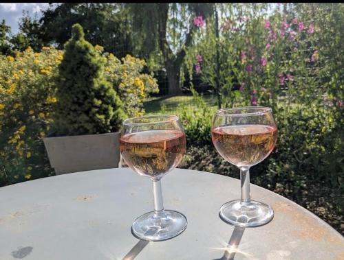two glasses of wine sitting on top of a table at Gîte du Saule du Magne 2 personnes in Douzy