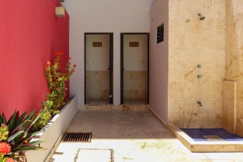 a hallway with two doors in a red wall at Hotel MX portal maya in Playa del Carmen