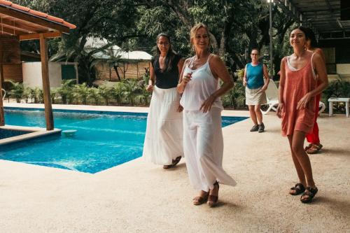 a group of women walking by a swimming pool at Rusteak Living Retreat in natural and peaceful setting in Canafistula in Cañafístula