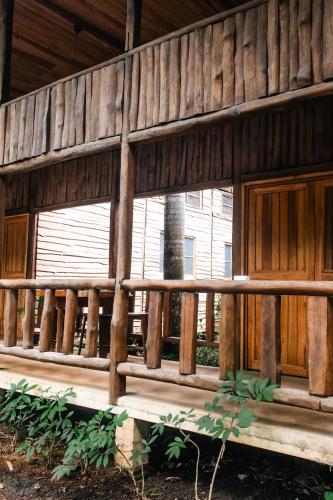 a wooden porch of a house with a wooden fence at Rusteak Living Retreat in natural and peaceful setting in Canafistula in Cañafístula