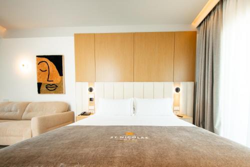 a bedroom with a large bed and a couch at Saint Nicolas Hotel in Himare