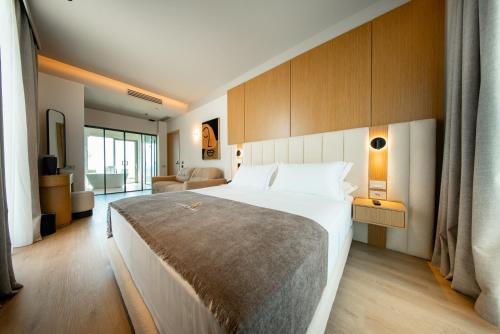 a bedroom with a large bed and a living room at Saint Nicolas Hotel in Himare