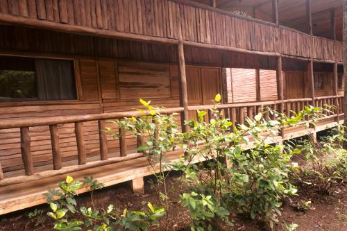 a wooden building with benches in front of it at Rusteak Living Retreat in natural and peaceful setting in Canafistula in Cañafístula