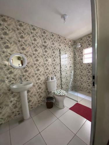 a bathroom with a toilet and a sink at Pousada Três Pescadores in Aparecida