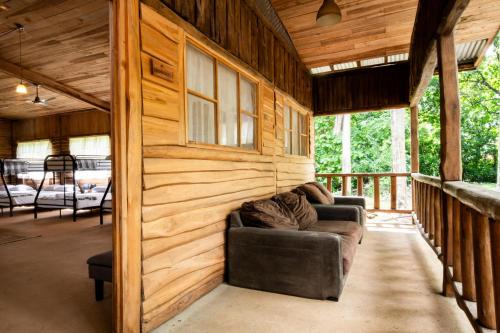 a living room in a log cabin with a couch at Rusteak Living Retreat in natural and peaceful setting in Canafistula in Cañafístula