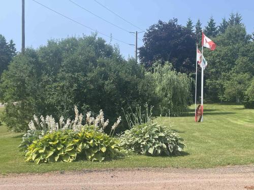 a flag and some plants in a field at Rose Valley Suites in Prince Edward Island