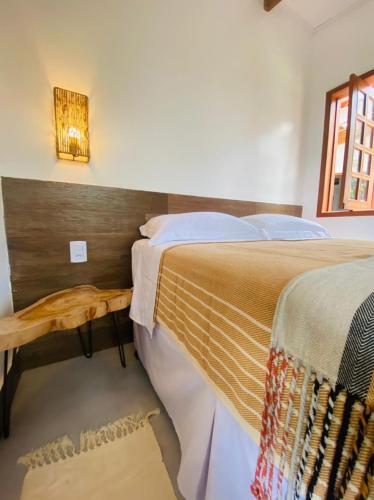 a bedroom with a bed with a wooden head board at Pousada Casa da Kátia Lagoa do Cassó in Mata Grande