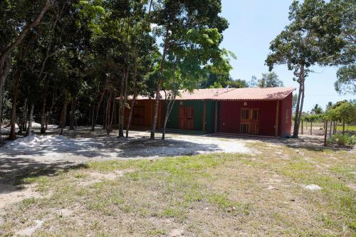a red and green building with trees in front of it at Chalés Borborema Cumuru in Prado