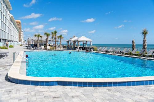 a swimming pool with the ocean in the background at Grand Seas MOD Collection by Sonesta in Daytona Beach