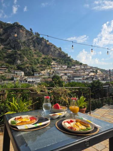 a table with food on it with a view of a mountain at MEROLI Guesthouse - UNESCO quarter in Berat