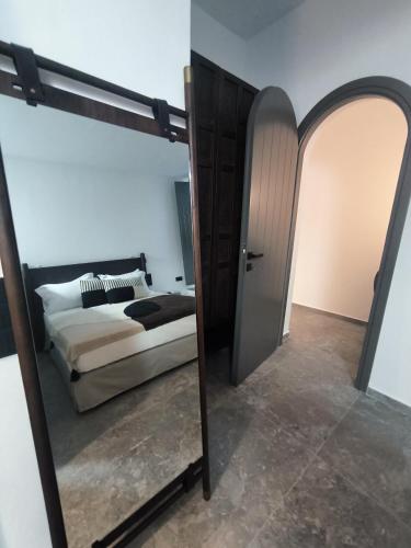 a bedroom with a bed and a large mirror at Koniko Santorini Private Pool Villas in Santorini