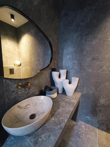 a bathroom with a sink and a mirror at Koniko Santorini Private Pool Villas in Santorini