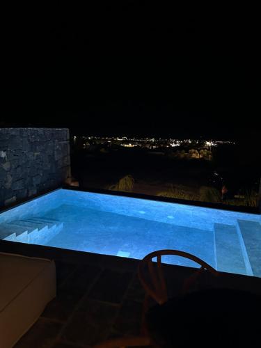 a swimming pool at night with a view at Koniko Santorini Private Pool Villas in Santorini