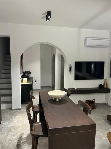 a living room with a table and some chairs at Koniko Santorini Private Pool Villas in Santorini