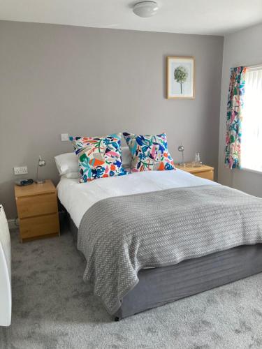 een slaapkamer met een groot bed met kussens bij Ludford View, riverside cottage in Ludlow with private parking in Ludlow